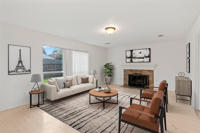 living room with a fireplace and light wood-type flooring