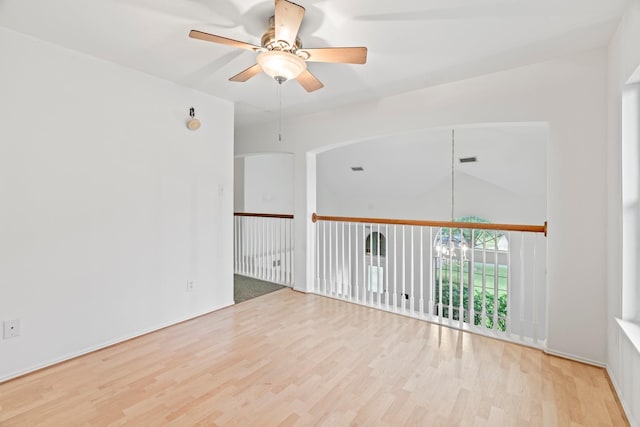 empty room with ceiling fan and light hardwood / wood-style floors