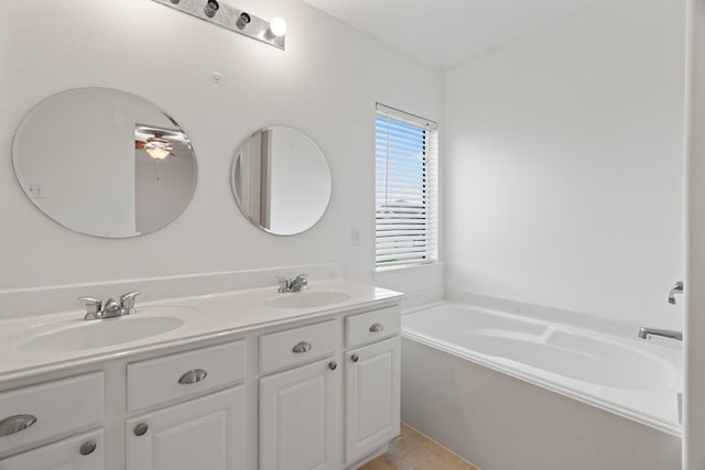 bathroom with tile patterned floors, ceiling fan, a tub to relax in, and vanity