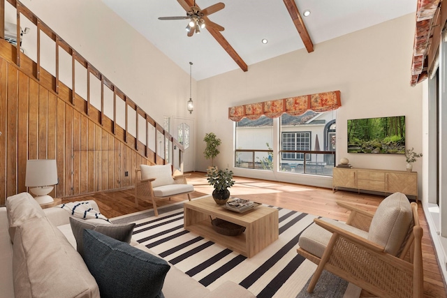 living room featuring beamed ceiling, wood-type flooring, high vaulted ceiling, and ceiling fan