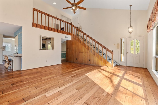 foyer entrance featuring light wood-type flooring, high vaulted ceiling, and ceiling fan