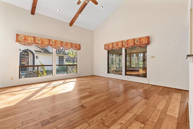 unfurnished living room with ceiling fan, beam ceiling, wood-type flooring, and high vaulted ceiling