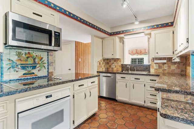 kitchen featuring decorative backsplash, stainless steel appliances, white cabinets, and sink