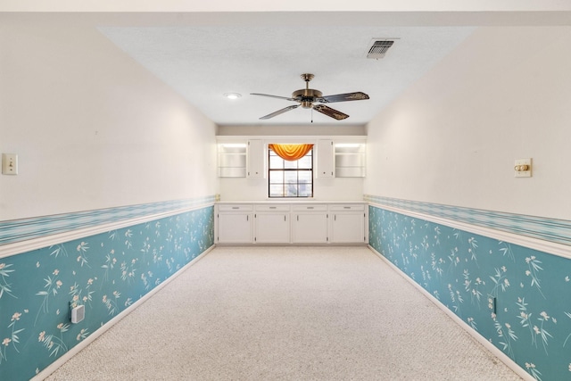 empty room featuring ceiling fan and light carpet