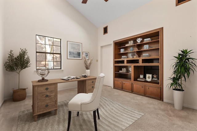 carpeted office space featuring high vaulted ceiling and ceiling fan