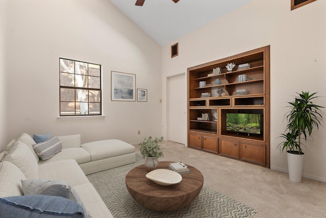 living room featuring built in shelves, ceiling fan, high vaulted ceiling, and light colored carpet