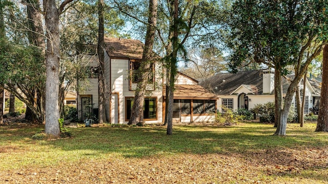 view of front of home with a sunroom and a front lawn