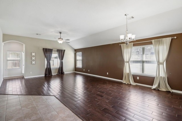 spare room featuring ceiling fan with notable chandelier and vaulted ceiling