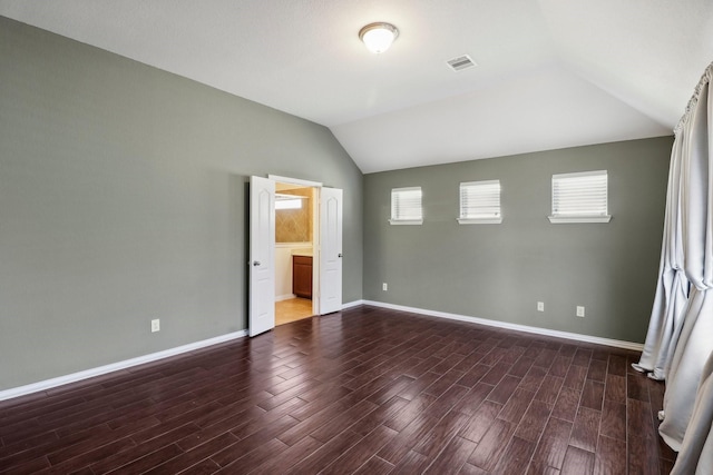 unfurnished bedroom featuring vaulted ceiling and ensuite bath