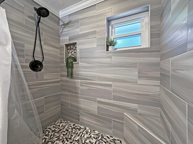 bathroom featuring a textured ceiling and tiled shower