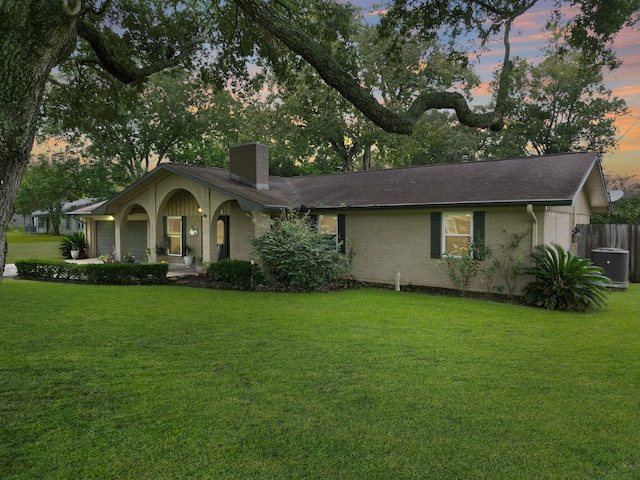 ranch-style house featuring a lawn and a garage