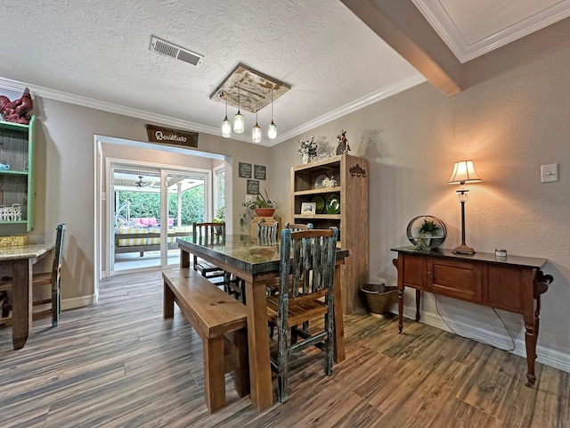 dining area with beam ceiling, a textured ceiling, dark wood-type flooring, and ornamental molding