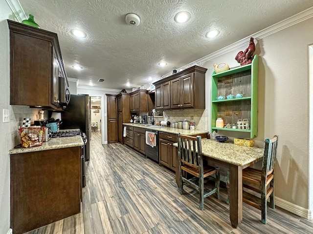 kitchen with dishwasher, stove, dark hardwood / wood-style floors, decorative backsplash, and dark brown cabinetry