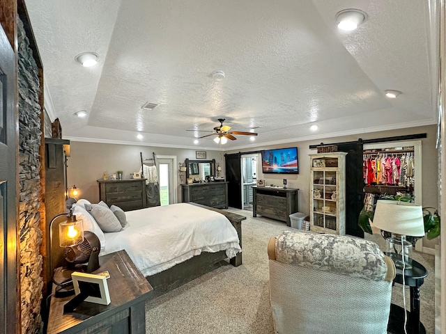 bedroom featuring carpet flooring, ceiling fan, a barn door, crown molding, and a textured ceiling