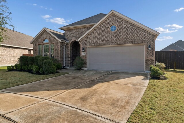 view of front of property with a front yard and a garage