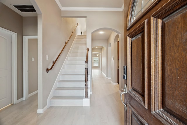 entryway featuring light hardwood / wood-style floors and ornamental molding