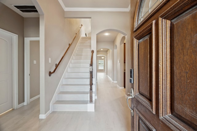 2206 Wolf Creek Ct, Katy, TX 77493 - foyer entrance featuring baseboards, light wood-style floors, crown molding, stairs, and arched walkways