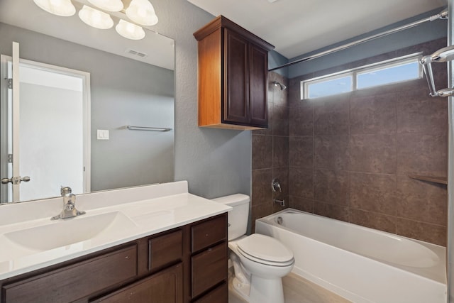 full bathroom with vanity, toilet, and tiled shower / bath