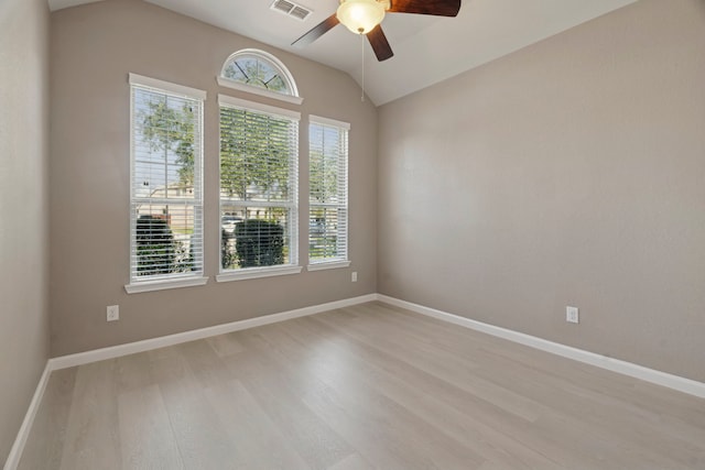 spare room with ceiling fan, lofted ceiling, and light wood-type flooring