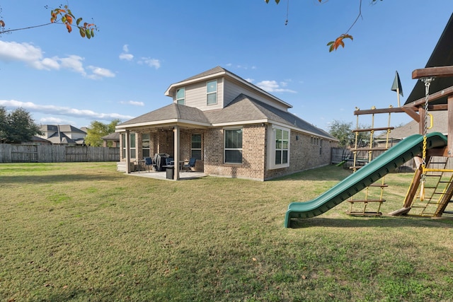 back of house featuring a lawn, a playground, and a patio