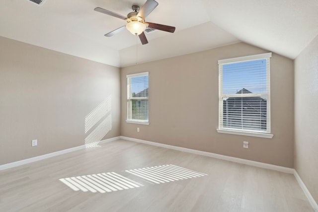 empty room featuring ceiling fan, light hardwood / wood-style flooring, and vaulted ceiling