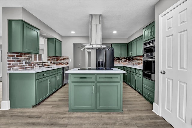 kitchen with island exhaust hood, decorative backsplash, sink, green cabinetry, and a kitchen island