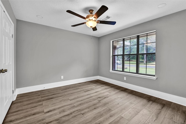 empty room with ceiling fan and hardwood / wood-style floors