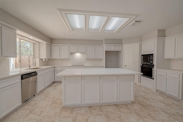 kitchen with a center island, white cabinets, black appliances, and sink