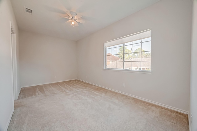 empty room featuring ceiling fan and light colored carpet