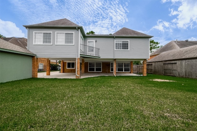 rear view of house with a lawn and a patio