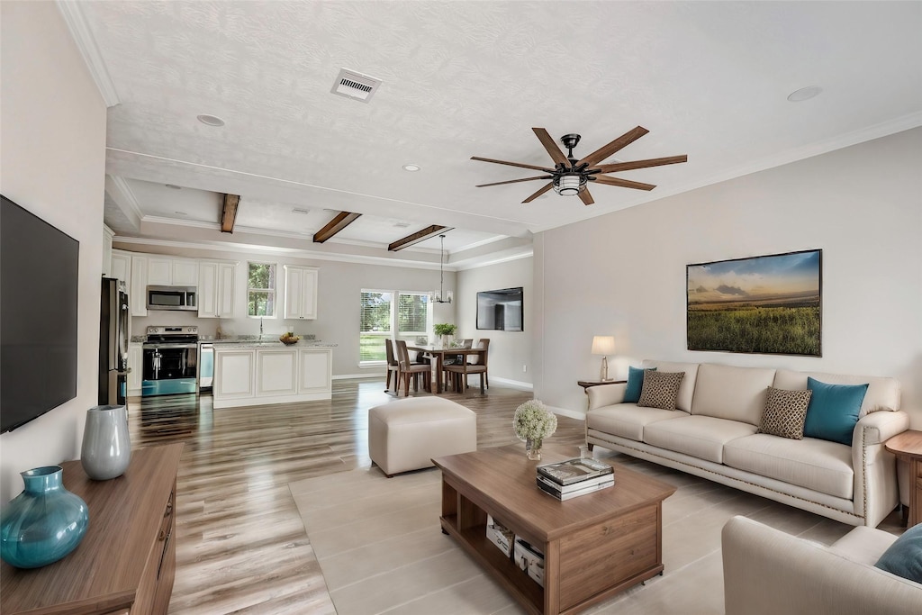 living room with ceiling fan, crown molding, sink, beam ceiling, and light hardwood / wood-style flooring