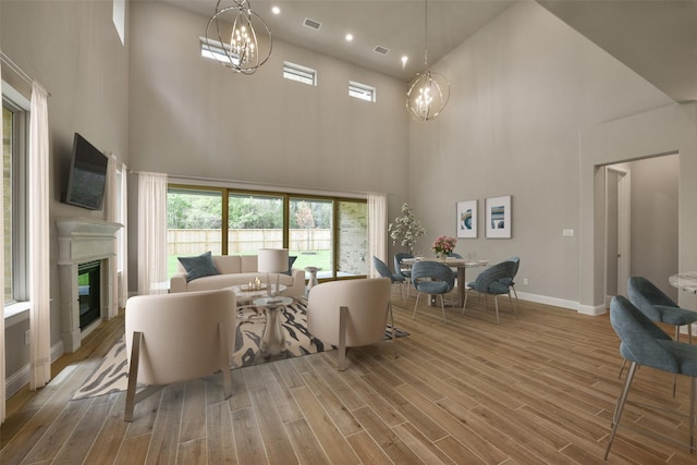 16146 Rustling Woods Rd, Conroe, TX 77302 - living room featuring a high ceiling, wood finished floors, a glass covered fireplace, healthy amount of natural light, and recessed lighting