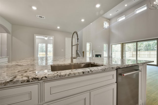 16146 Rustling Woods Rd, Conroe, TX 77302 - kitchen with white cabinets, light stone counters, recessed lighting, a ceiling fan, and decorative light fixtures