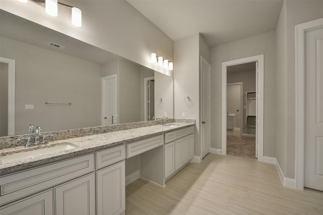 16146 Rustling Woods Rd, Conroe, TX 77302 - bathroom featuring double vanity and wood finished floors