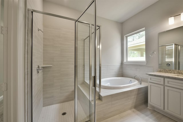 16146 Rustling Woods Rd, Conroe, TX 77302 - bathroom featuring vanity, a garden tub, a shower stall, and tile patterned flooring