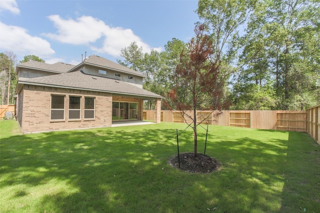 16146 Rustling Woods Rd, Conroe, TX 77302 - rear view of property featuring a fenced backyard, brick siding, a shingled roof, and a patio area