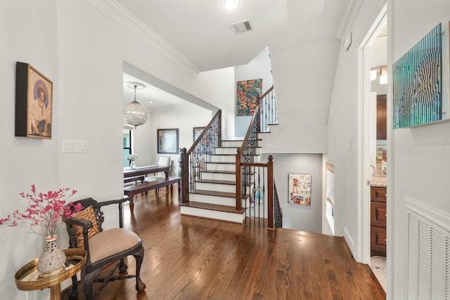 entryway featuring crown molding, an inviting chandelier, and hardwood / wood-style flooring