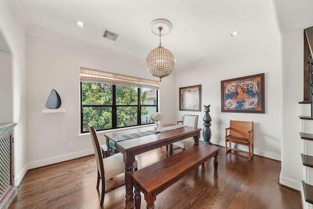 dining space featuring dark hardwood / wood-style flooring, an inviting chandelier, and ornamental molding