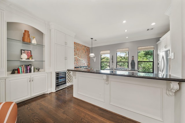 kitchen with white cabinetry, beverage cooler, built in features, stainless steel refrigerator with ice dispenser, and decorative light fixtures