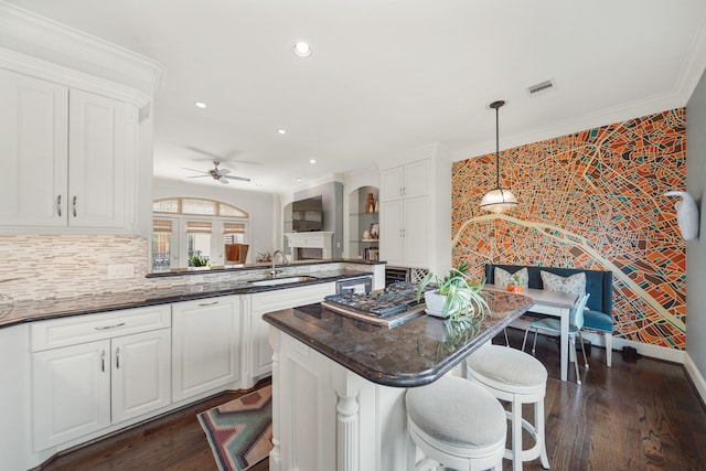 kitchen with ceiling fan, sink, white cabinets, and hanging light fixtures