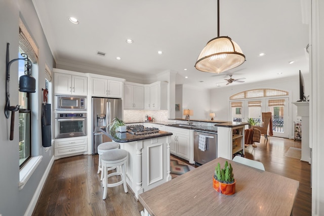 kitchen with white cabinetry, sink, ceiling fan, stainless steel appliances, and decorative backsplash