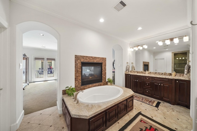 bathroom featuring vanity, french doors, tile patterned floors, crown molding, and a tub to relax in