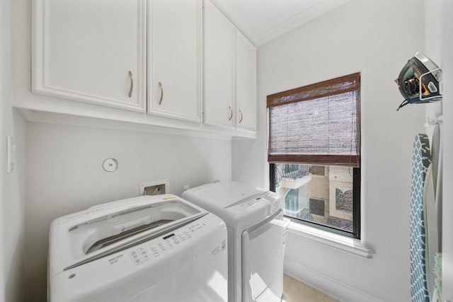 laundry area featuring cabinets, crown molding, and washing machine and dryer