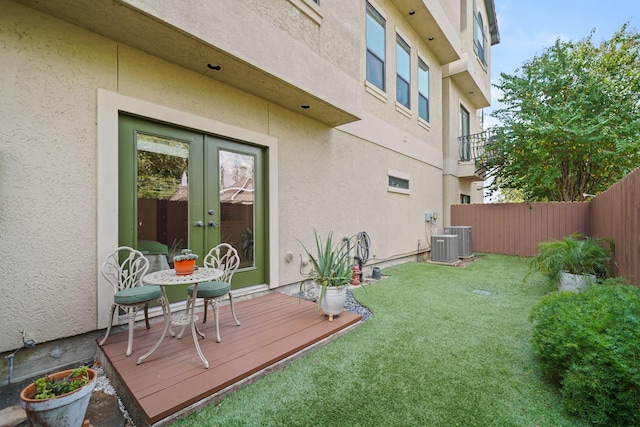 exterior space featuring a yard, central air condition unit, and french doors