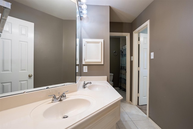 bathroom with tile patterned floors, walk in shower, vanity, and toilet