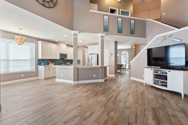 kitchen with decorative backsplash, stainless steel appliances, decorative light fixtures, a chandelier, and a center island