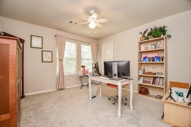 office area featuring baseboards, visible vents, ceiling fan, and light colored carpet