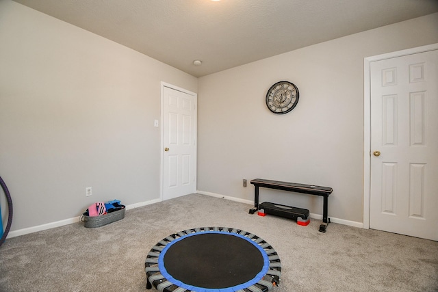 exercise area featuring carpet floors and baseboards