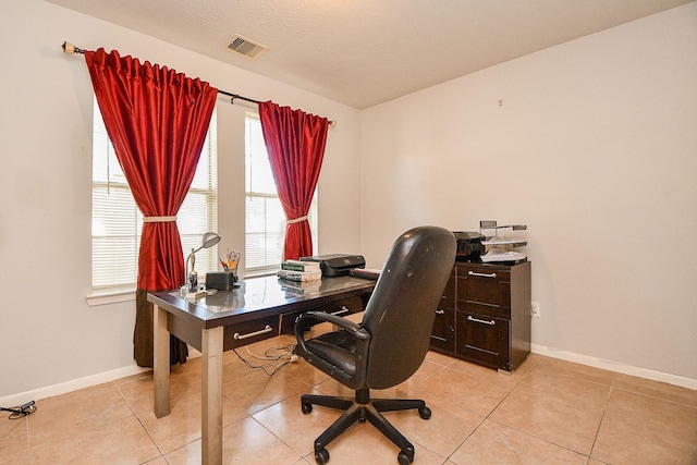 office featuring light tile patterned floors, baseboards, visible vents, and a textured ceiling