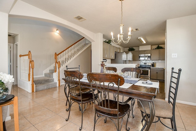 dining area featuring visible vents, stairway, an inviting chandelier, and light tile patterned floors